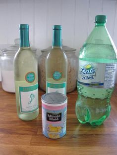 several bottles of water and other items on a wooden counter top in front of jars