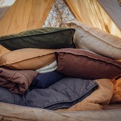 a pile of pillows and blankets in a tent