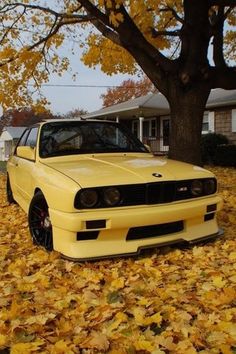 a yellow car is parked in the leaves