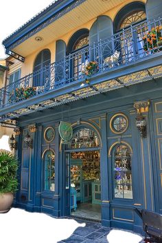 an ornately decorated building with blue doors and balconies on the second floor