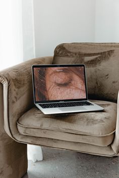 an open laptop computer sitting on top of a chair