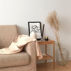 a living room with a couch, table and vase