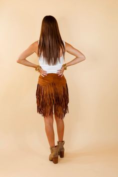 Elevate your wardrobe with our Pep Into Your Step Fringe Skirt! This beauty will have you looking stylish and confident with the eye-catching zig zag fringe on the bottom. Get ready to turn heads and move with grace. Show off your style! Fringe reaches 7 inches below skirt length. Arté is wearing a size small. Size Suggestions: Small: 2-4 | Waist: 26 inches around | Length: 13.5 inches Medium: 6-8 | Waist: 29 inches around | Length: 14.5 inches Large: 10-12 | Waist: 32 inches around | Length: 15 Bohemian Tassel Bottoms For Fall, Bohemian Brown Bottoms With Fringe, Bohemian Brown Fringe Bottoms, Fringe Mini Skirt For Festival, Brown Mini Skirt For Festival, Fall Festival Fringe Skirt, Bohemian Fringe Bottoms For Fall, Bohemian Fringed Bottoms For Fall, Trendy Fringe Skirt