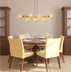 a dining room table with yellow chairs and lights