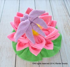 a pink and green flower on top of a wooden table