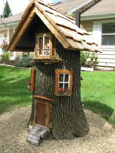 a tree house made out of branches with a roof and windows on the top floor