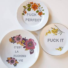 three plates with flowers painted on them that say luck, perfect and fokt