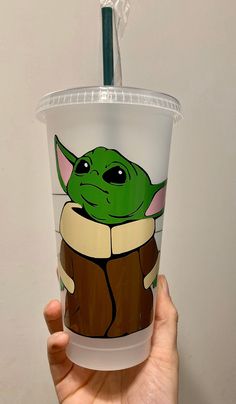 a hand holding a starbucks cup with an image of the child yoda on it