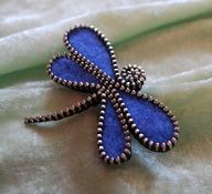 a blue brooch sitting on top of a white cloth