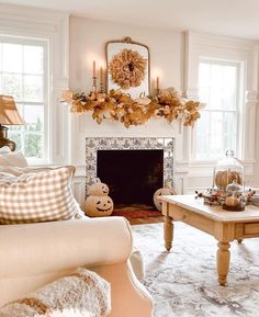 a living room filled with furniture and a fire place in front of a fireplace covered in pumpkins