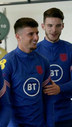 two men standing next to each other smiling