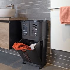 a black trash can sitting next to a sink