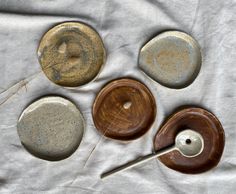 four different types of pottery sitting on top of a white cloth covered table next to each other