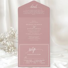 a pink and white wedding card with the wording on it is next to a bouquet of flowers