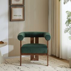 a green chair sitting in front of a window next to a table and potted plant