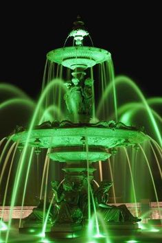 a green fountain lit up at night with lights