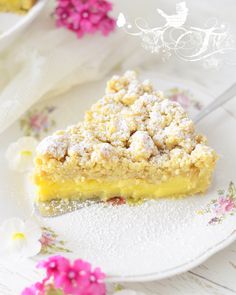 a piece of lemon crumb cake on a white plate with pink flowers in the background