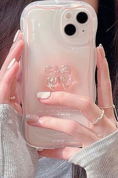 a woman is holding up her phone case with a bow on it's side