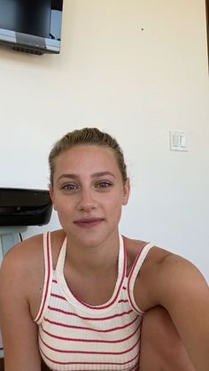 a young woman sitting in front of a flat screen tv