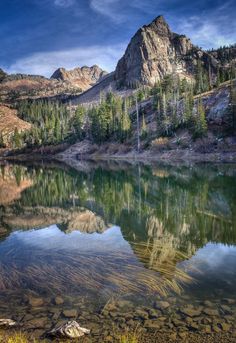 the mountains are reflected in the still water of this lake, and it's reflection is clearly visible