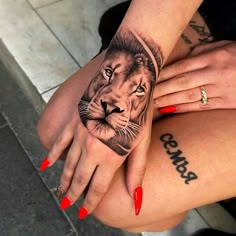 a woman's hand with a lion tattoo on the left side of her leg