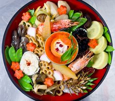 a red bowl filled with lots of different types of food on top of a table