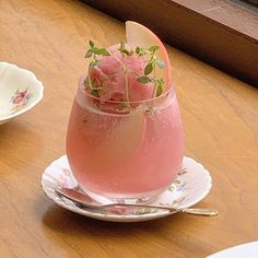 a glass filled with watermelon sitting on top of a table next to a plate