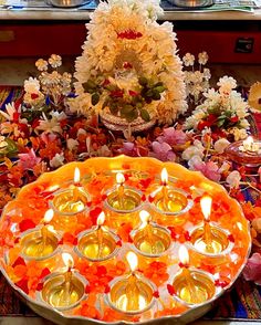 an arrangement of candles and flowers on a table