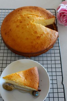 a piece of cake sitting on top of a white plate next to a pink rose