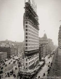 an old black and white photo of a building being constructed in the middle of a city