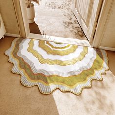 a rug on the floor in front of a door with a potted plant next to it