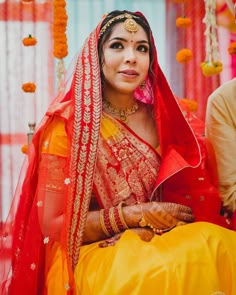 a woman in red and yellow is sitting down