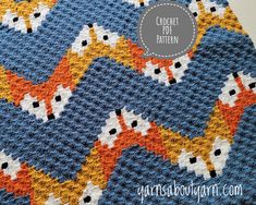 a crocheted blanket with an orange and blue pattern