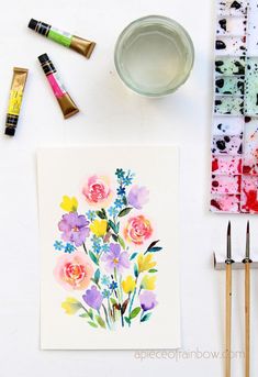 watercolor flowers and paint are on the table