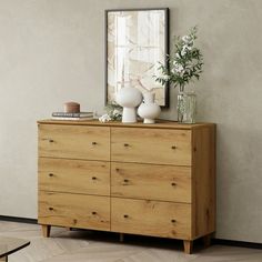 a wooden dresser with vases on top of it and a mirror over the top