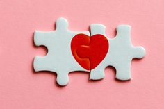 a puzzle piece with a red heart on it's side and the other two pieces missing