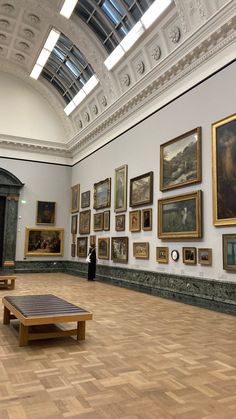 a large room filled with paintings and wooden benches