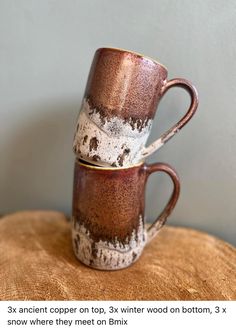 two coffee mugs stacked on top of each other