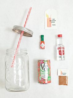 the contents of a mason jar are laid out on a white surface, including candy canes, peppermint, and an empty bottle