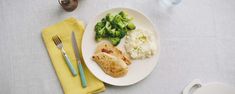 a white plate topped with meat, mashed potatoes and broccoli