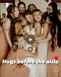 a group of women standing next to each other in front of a wall with the words hugs before the aisle