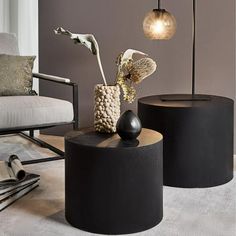 two black tables sitting on top of a white carpeted floor next to a chair