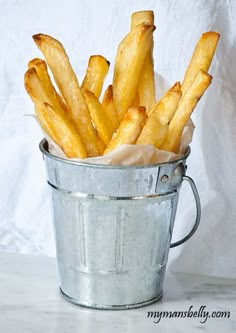 a bucket full of french fries sitting on top of a table