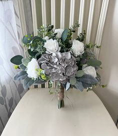 a bouquet of flowers sitting on top of a white table next to a window sill