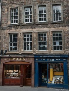 an old brick building with several windows on the front and side of it's storefront