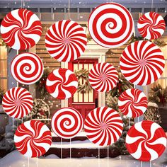 red and white lollipops hanging from strings in front of a christmas display