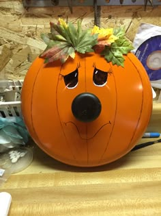 a pumpkin shaped like a dog with leaves on its head