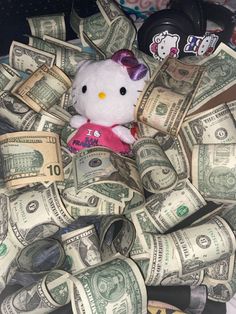 a hello kitty stuffed animal surrounded by money