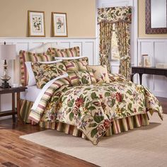 a bed room with a neatly made bed next to a dresser and window covered in curtains