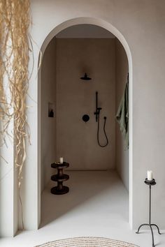 an archway leading into a bathroom with a shower head and hand held shower faucet